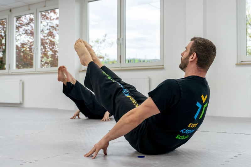 Trainer Felix zeigt eine anstrengende Übung die sehr viel durchhaltevermögen beansprucht